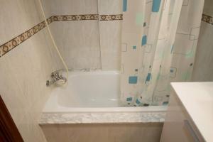 eine weiße Badewanne im Bad mit einem Duschvorhang in der Unterkunft Los Molinos, con terraza in Corcubión