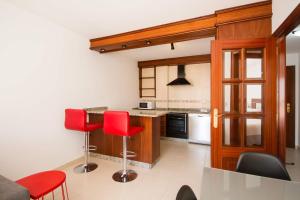 eine Küche mit roten Stühlen und einem Tisch in der Unterkunft Los Molinos, con terraza in Corcubión