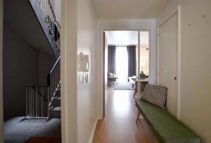 a hallway with a staircase and a green bench at Spot Apartments in Porto
