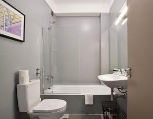 Baño blanco con aseo y lavamanos en Spot Apartments en Oporto