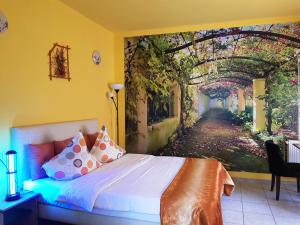 a bedroom with a bed with a painting on the wall at Pensiunea Paloma 3 stele Brasov in Braşov