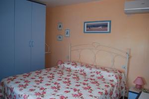 1 dormitorio con 1 cama con colcha de flores en Rustico Rosmarino, en Castiglion Fiorentino