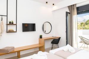 a bedroom with two beds and a desk and a mirror at alemár in Tinos