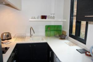 a white kitchen with a sink and a window at Burdigala Homes - Les Apparts de la Course in Bordeaux