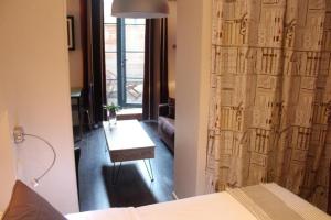 a room with a bed and a table and a curtain at L'Appart de la Course in Bordeaux