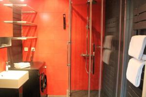 a red bathroom with a shower and a sink at L'Appart de la Course in Bordeaux +20 photos