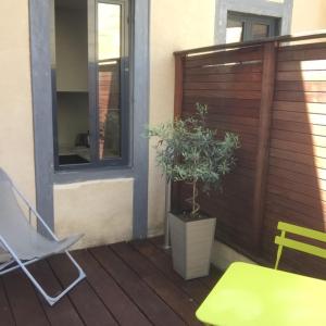 a patio with a table and a potted plant at L'Appart de la Course in Bordeaux