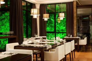 a dining room with tables and white chairs and windows at Swan Novo Hamburgo in Novo Hamburgo