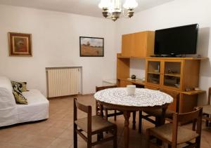 ein Wohnzimmer mit einem Tisch und einem TV in der Unterkunft Little Star pioppa in Riondi
