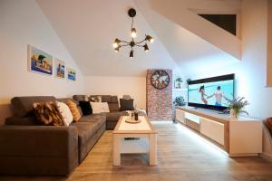 uma sala de estar com um sofá e uma televisão de ecrã plano em Apartment Ana-Marija em Trogir