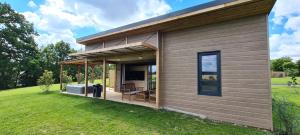 a small house with a deck with a television at Domaine des graminées in Jeanménil