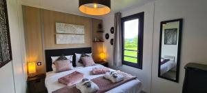 a bedroom with a large bed with pink pillows at Domaine des graminées in Jeanménil