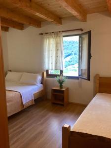 una camera da letto con due letti e una finestra di Guest house PANORAMA a Theth