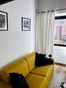 a yellow couch in a living room with a window at Localetto bed & dinner in Sutri
