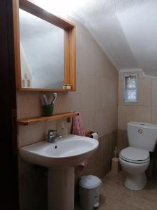 a bathroom with a sink and a toilet and a mirror at Papaioannou - Gomati Chalkidikis in Megáli Panayía