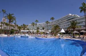 a large swimming pool next to a large hotel at Altamira Apartamentos Adeje in Adeje