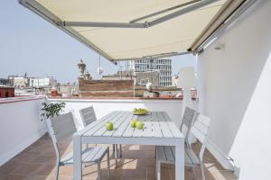 a white table and chairs on a balcony at Ola Living Santa Anna in Barcelona