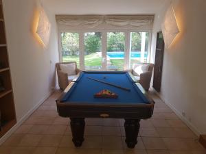 una mesa de billar en una sala de estar con una piscina hibitionhibition en Villapinheiros, en Vilamoura
