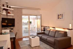 Villino Sabbia d'Oro في سان فينتْشينسو: غرفة معيشة مع أريكة بنية وطاولة