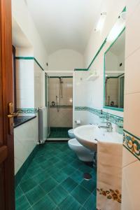 a bathroom with two toilets and a sink and a shower at Roccia Fiorita in Furore