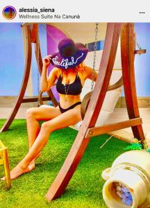 Eine Frau im Bikini, die in einer Schaukel sitzt. in der Unterkunft Wellness Suite Na' Canuna' in Roddi