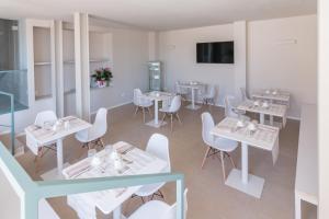 a dining room with white tables and white chairs at bed&breakfast Filomare in Numana