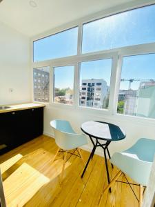 a room with a table and chairs and windows at The Postcard Avenue in Lisbon