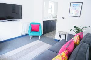 a living room with a couch and a blue chair at New street Luxury town house in the centre of Holt with free PARKING for one car in Holt