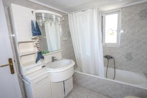 a bathroom with a sink and a tub and a toilet at Aqua Mare in Amoudara Herakliou +38 photos