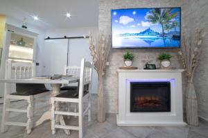 a living room with a fireplace and a tv on the wall at LA VEGUILLA DELUXE JACUZZi in Alhama de Aragón