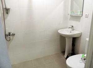 un bagno bianco con lavandino e WC di Hotel Lopota Gate a Napareuli