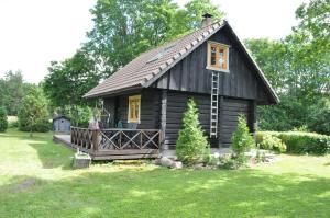 a small log cabin in a field of grass at Villa Verde in Kihelkonna