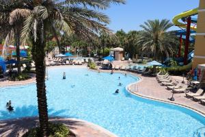 a pool at a resort with palm trees and people in it at FantasyWorld Resort in Kissimmee