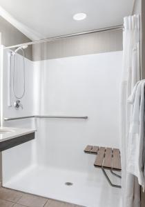 ein weißes Bad mit einer Dusche und einem Waschbecken in der Unterkunft Holiday Inn Lafayette-City Centre, an IHG Hotel in Lafayette