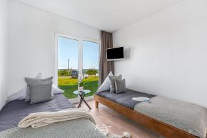 two beds in a room with a window at Fjordblick in Olpenitz