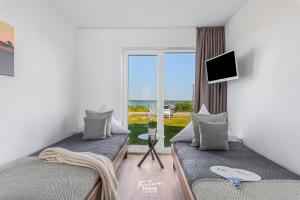 a room with two beds with a view of the ocean at Fjordblick in Olpenitz