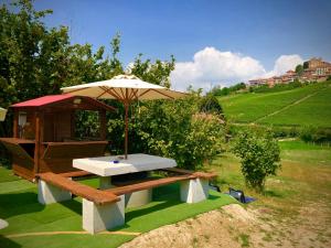 a picnic table with an umbrella in a field at Wellness Suite Na' Canuna' in Roddi