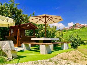 a picnic table with an umbrella and a bench at Wellness Suite Na' Canuna' in Roddi