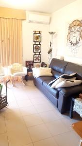 a living room with a black leather couch at Modern Apartment in Calafell + Terrace in Calafell