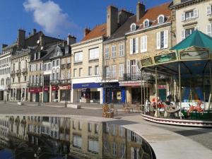 a city street with buildings and a reflection in the water at Etape Moulinoise (rez-de-chaussée) in Moulins