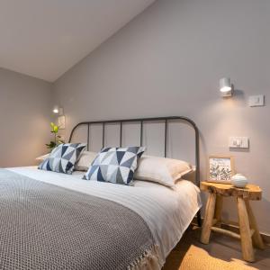 1 dormitorio con 1 cama con almohadas azules y blancas en QUERCUS apartments, secluded and next to the bike trail, en Funtana