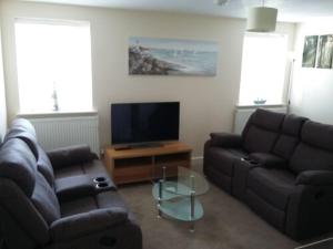 a living room with two couches and a television at Harrington Flats in Newquay