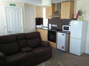 a living room with a couch and a kitchen at Harrington Flats in Newquay