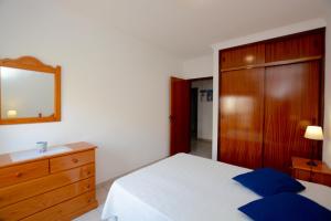 a bedroom with a bed and a dresser and a mirror at Casa Rabelo C in Armação de Pêra +7 photos