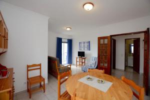 a living room with a wooden table and chairs at Casa Rabelo C in Armação de Pêra