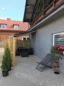 a patio with a table and a bench on a patio at U Jagódki in Warpuny