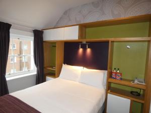 a bedroom with a large bed and a large window at Jackson Court Hotel in Dublin