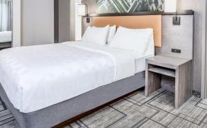 sypialnia z dużym łóżkiem i stołem w obiekcie Holiday Inn Lafayette-City Centre, an IHG Hotel w mieście Lafayette