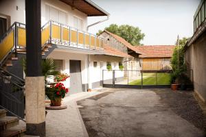 a courtyard of a house with a balcony and a fence at Apartman Kuća 150 in Mala Subotica