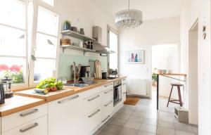 cocina con armarios blancos y encimera en WÄLDER: Quartier St.Blasien, en St. Blasien